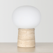 Travertine Globe Table Lamp on a neutral concrete tabletop