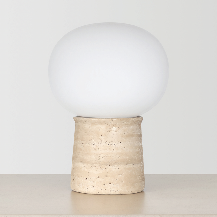 Travertine Globe Table Lamp on a neutral concrete tabletop