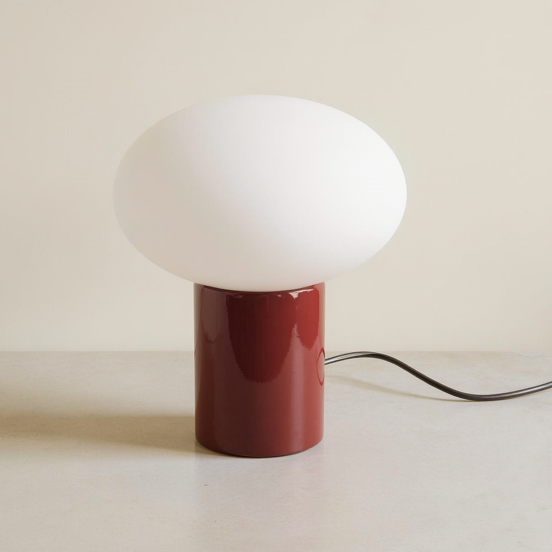 Frosted Globe Oval Table Lamp on a neutral concrete tabletop