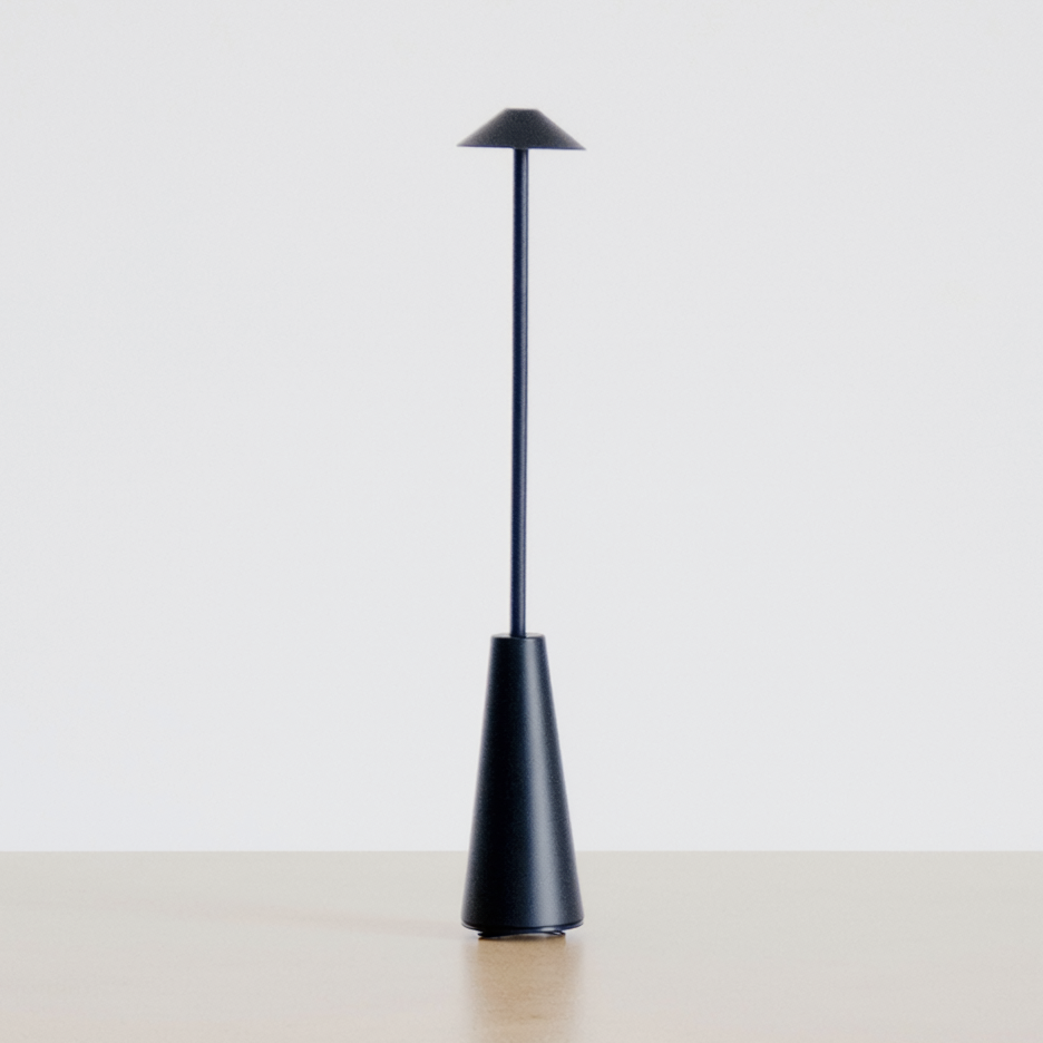 Matte Black Portable Rechargeable Table Lamp on a neutral concrete tabletop