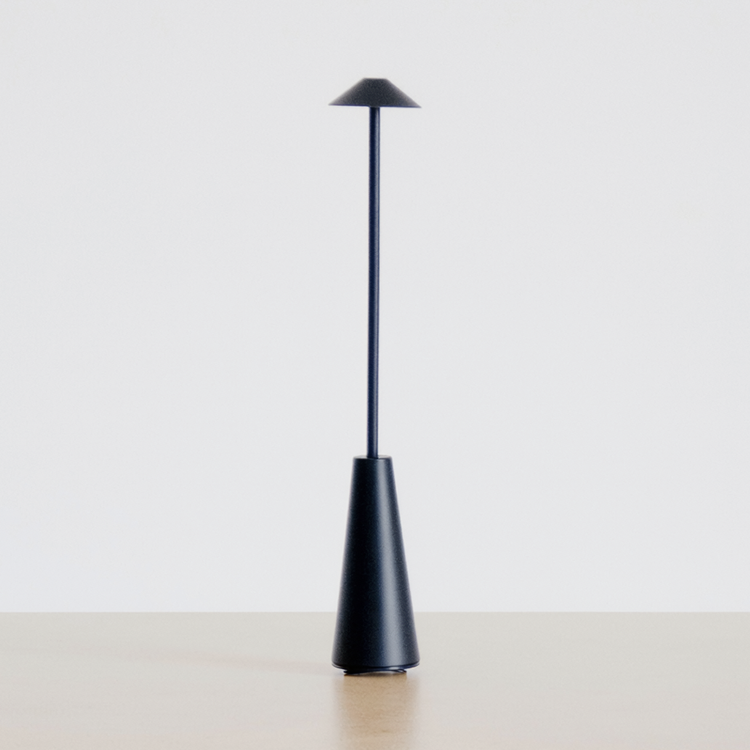 Matte Black Portable Rechargeable Table Lamp on a neutral concrete tabletop