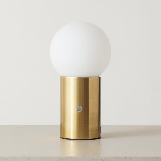Brass USB Table Lamp with Frosted Glass Globe on a neutral concrete tabletop