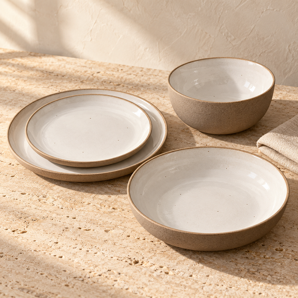 Speckled Stoneware Dinnerware Set — Set of all 4 pcs., arranged on pale travertine in warm natural light