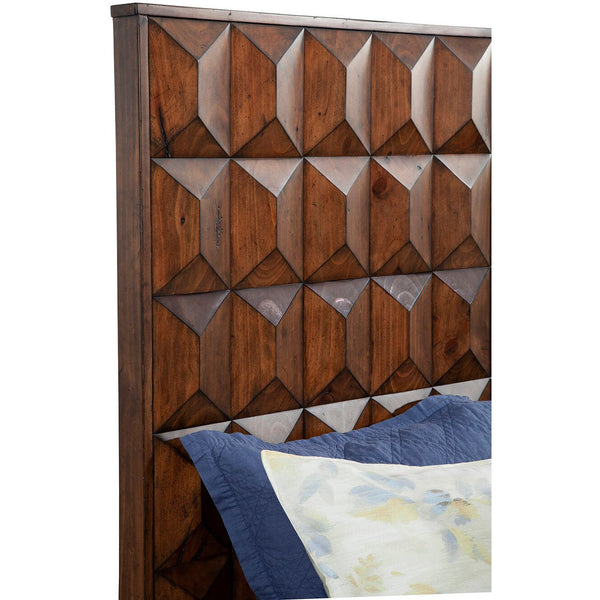 Close-up of raised diamond facets on brown headboard above blue and patterned pillows.