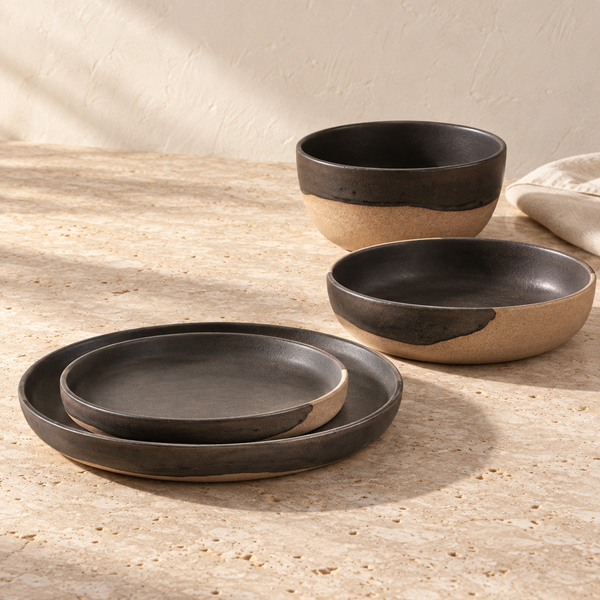 Two-Tone Glazed Stoneware Dinnerware Set — Set of all 4 pcs., arranged on pale travertine in warm natural light